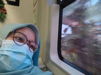 Portrait of mid adult man seen through train window