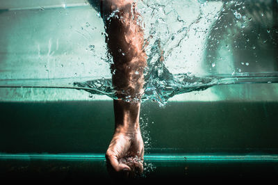 Low section of man swimming in pool