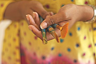 Midsection of woman holding paintbrushes