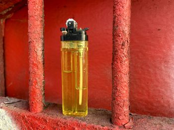 Close-up of red bell on table against wall