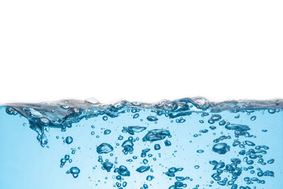 Close-up of water drops on glass against white background