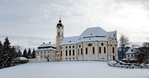 Exterior of wies church by snow covered field during winter