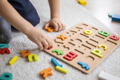 Midsection of man playing with toy blocks on table