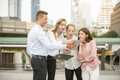 Group of people holding mobile phone in city