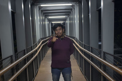 Low angle view of young woman standing on escalator