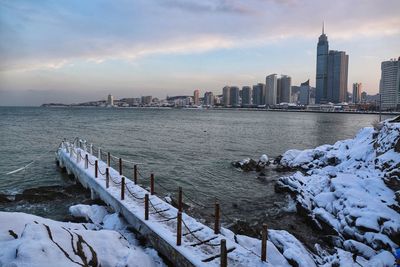 View of city at waterfront during sunset