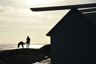 Silhouette man on beach against sky