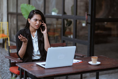 Young woman using laptop at table