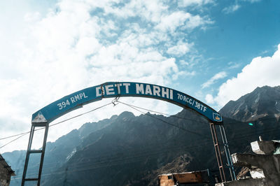 Low angle view of text on bridge against sky