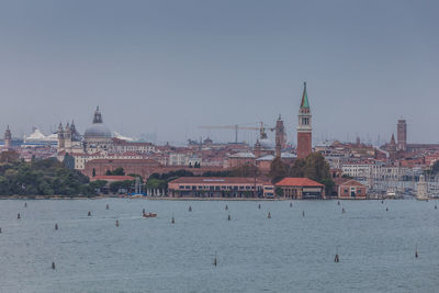 View of island of san giorgio, with port infrastructures and large cruise ships in the background