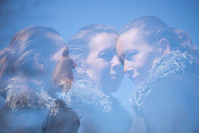 Close-up of young woman against blue sky