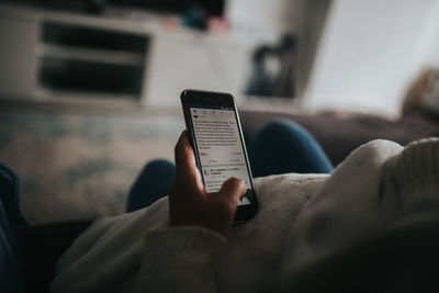 Close-up of man using mobile phone at home