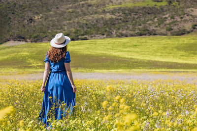 Rear view of woman standing on field