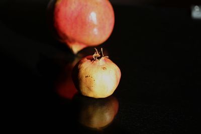 Close-up of apple on table against black background