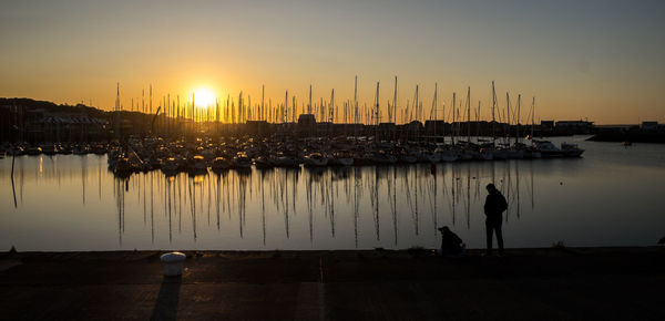 Howth, ireland - sunset at the harbour and a couple romantically looking at each other.