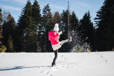 Full length of woman walking on snow covered land
