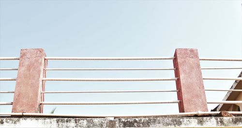 Low angle view of railing against clear sky