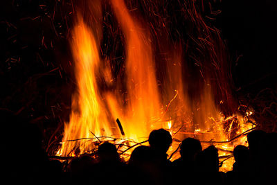 Silhouette people against fire at night