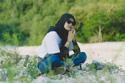 Full length of woman sitting on field