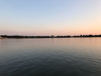 Scenic view of lake against clear sky during sunset