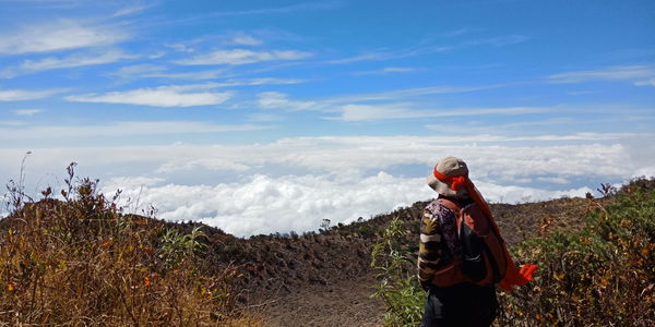 A lady looking at the white cotton clouds after a tiring hike at mt lawu,  indonesia