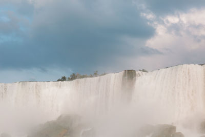 Scenic view of waterfall against sky