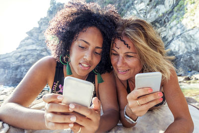 Portrait of smiling young woman using mobile phone