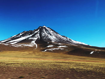 Scenic view of snowcapped mountain against clear blue sky