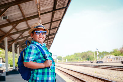 Portrait of smiling man standing on railroad track