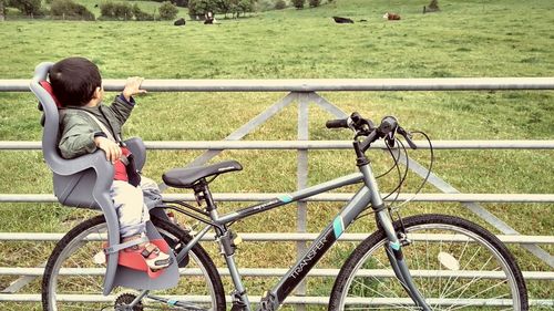 Full length of woman riding bicycle on field