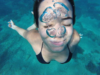 Woman with eyes closed swimming undersea