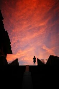 Silhouette people standing on railing