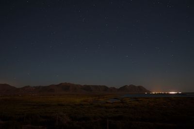 Scenic view of desert and distant town at night