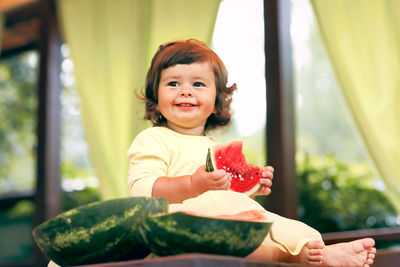 Girl eating watermelon on table