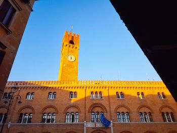 Low angle view of clock tower against blue sky