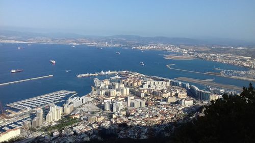 High angle view of city by sea against sky