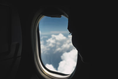 Close-up of airplane window against sky