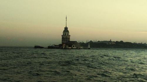 Lighthouse in sea against sky