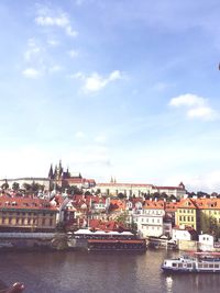 View of town by river against sky