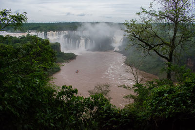 Scenic view of waterfall against sky