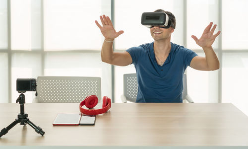 Man using mobile phone while sitting on table