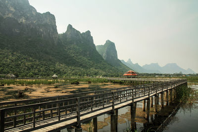 Bridge over mountain against sky