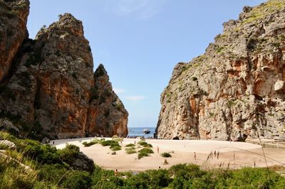 Rock formations by sea against sky