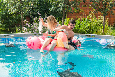 Full length of people enjoying in swimming pool