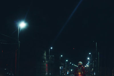 Low angle view of illuminated street lights at night