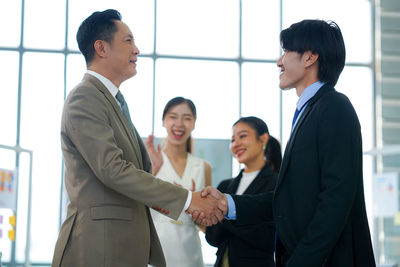 Business colleagues shaking hands in office