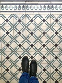 Low section of man standing on tiled floor