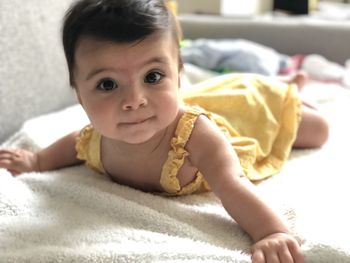 Portrait of baby girl lying on bed