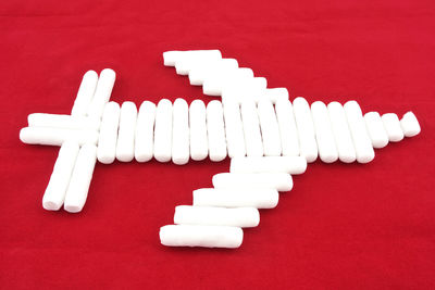 High angle view of airplane made with foam cylinder shapes on red background