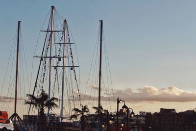 Cranes at harbor against sky